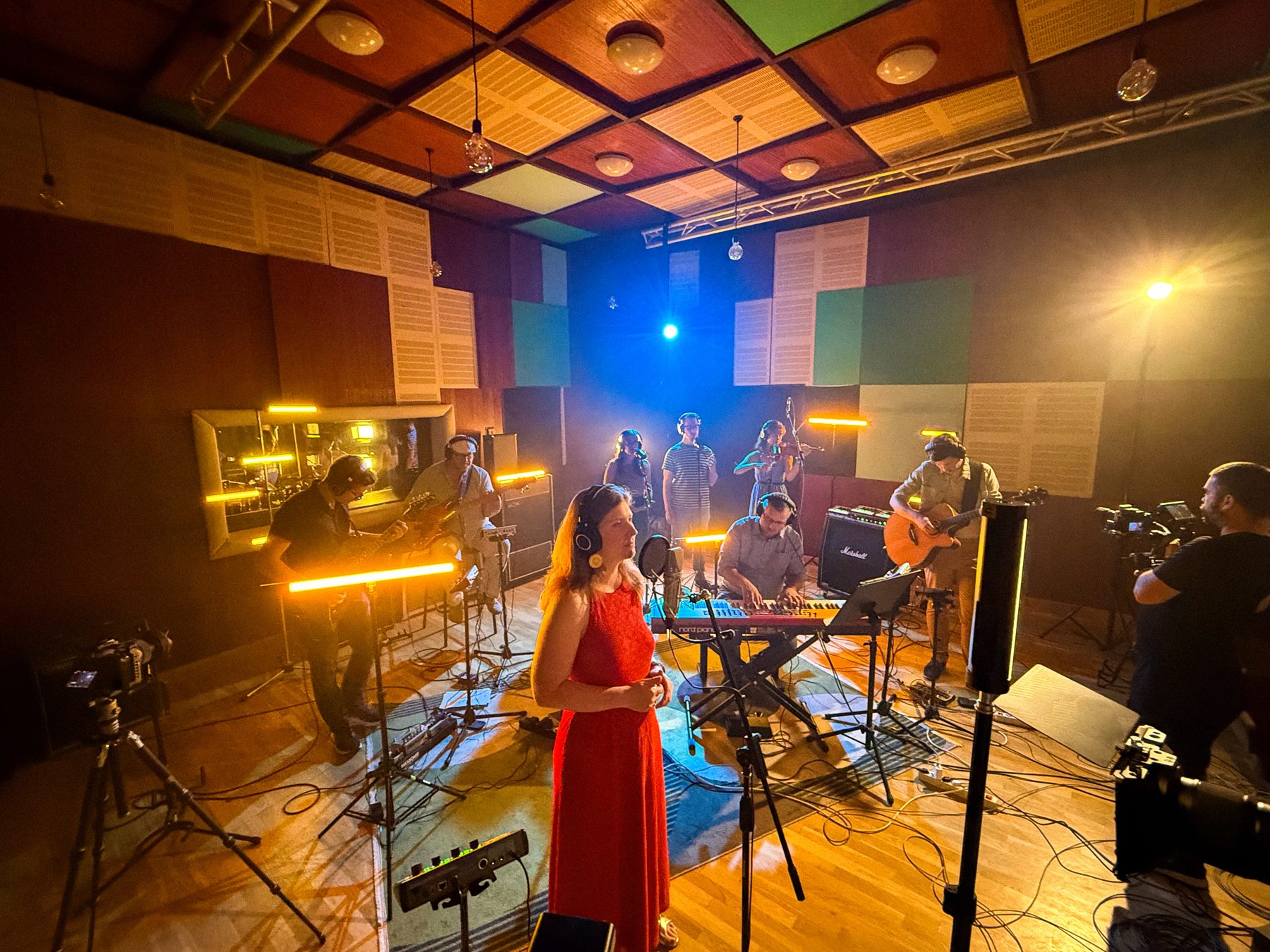 Szikra Live Session at ProVibe Studio: a singer in a red dress with the band, lights and camera crew